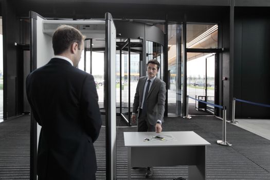 Man at airport security gates putting out phone and keys