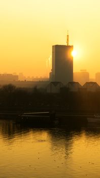 Sun going behind the building and view of the river Sava and urban scape of Belgrade city