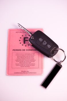 Car keys and drivers license on white background, France