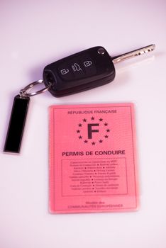 Car keys and drivers license on white background, France