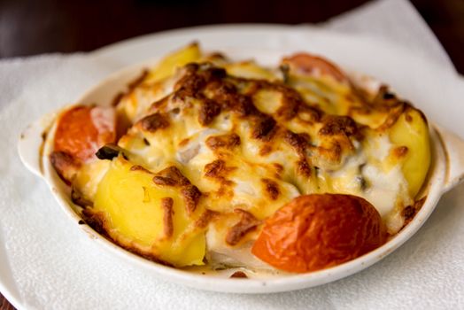 Potatoes with tomatoes baked with a cheese