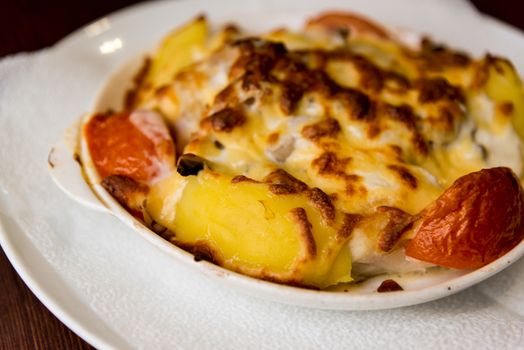 Potatoes with tomatoes baked with a cheese