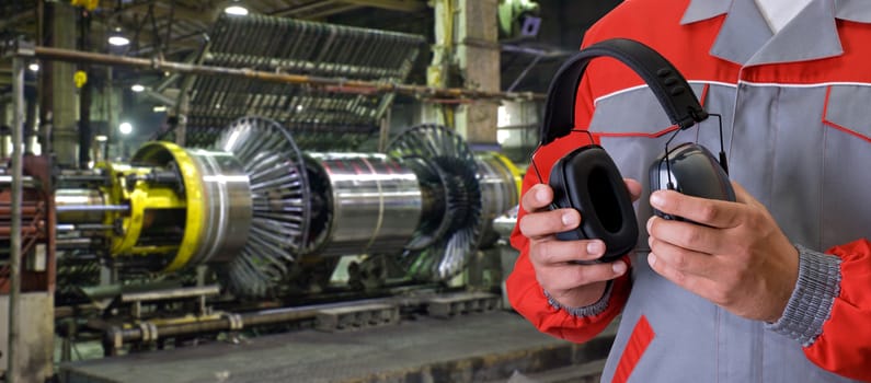 Worker with protective headphone at man hands at industrial factory