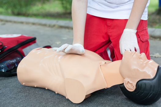 Paramedic practicing Cardiopulmonary resuscitation - CPR on a dummy. Cardiac massage.