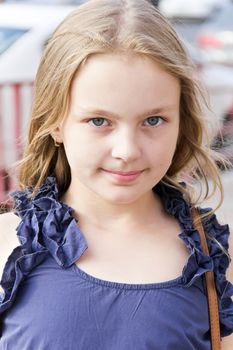Portrait of cute girl with blond hair in blue dress