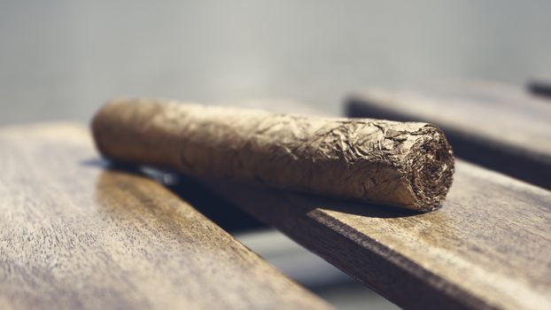 Cuban cigar resting on a wooden surface