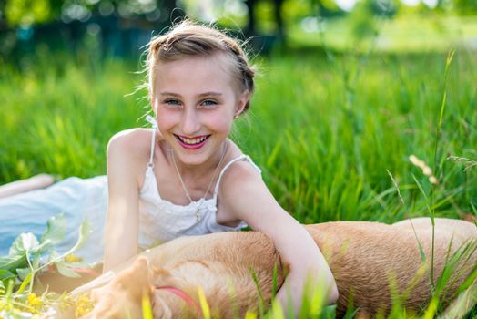 beautiful girl with a dog on the grass