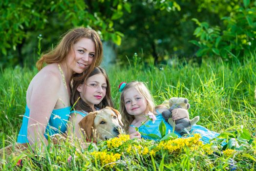mom with two daughters and dog in the garden