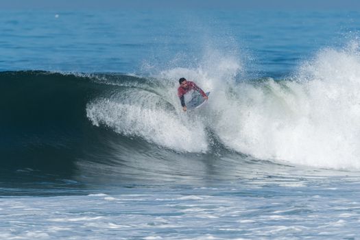 Bodyboarder in action on the ocean waves on a sunny day.