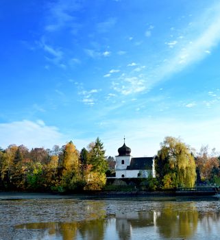 The church at pond with reflection in water and blue sky.