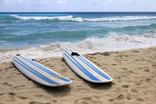 Surfboards at Dover beach on island Barbados on sandy shore by ocean