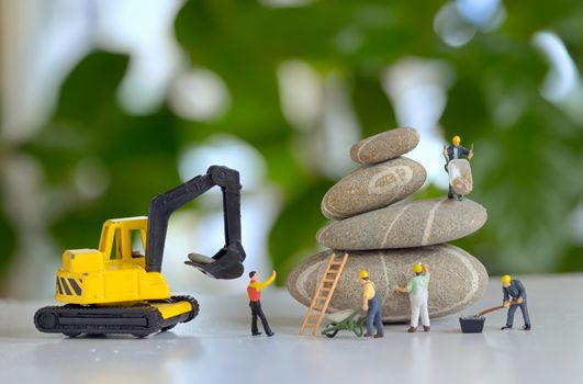 Pebbles stack and figurines of construction workers