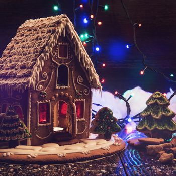 Gingerbread house with lights on dark background, xmas theme