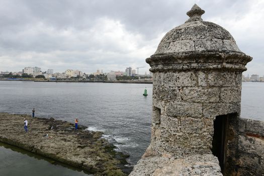 Havana, Cuba - 26 january 2016: People fishing at El Morro fortress with the city of Havana in the background, Cuba