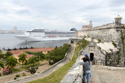 Havana, Cuba - 26 January 2016: people watching a cruiser ship entering the bay of Havana on Cuba