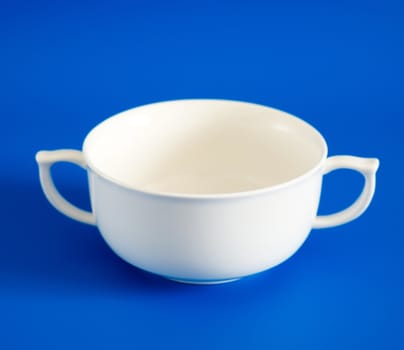 White cup of soup on a blue background