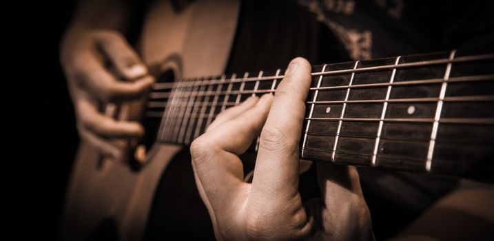 Close up of hands on the strings of a guitar, France
