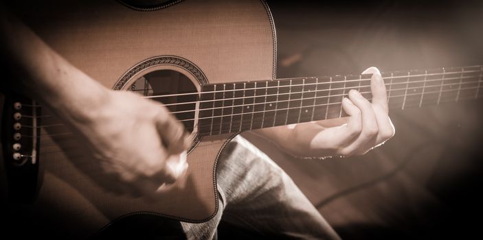 Close up of hands on the strings of a guitar, France