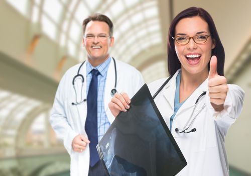 Doctors or Nurses With Thumbs Up Holding X-ray Standing Inside Hospital.