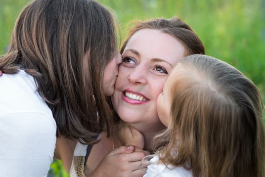 two daughters, Kiss mom in her cheeks
