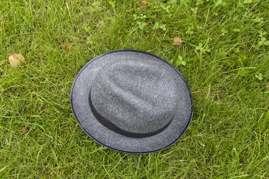 Men's Grey Hat lies summer day on the green grass