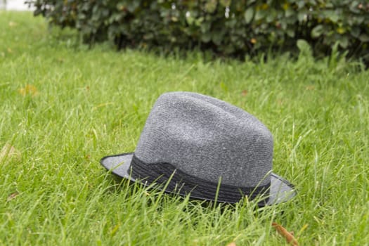 Men's Grey Hat lies summer day on the green grass