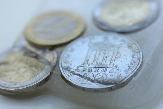 Frozen Assets: Greek euro and Drachme coins in ice