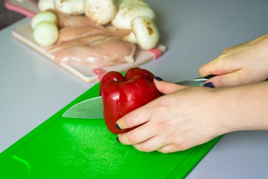 hand cut red bell pepper on the plastic green Board