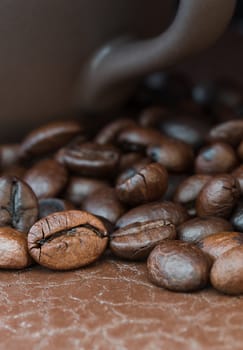 Close up roasted coffee beans and coffee cup