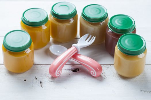 healthy ready-made baby food on a wooden table.