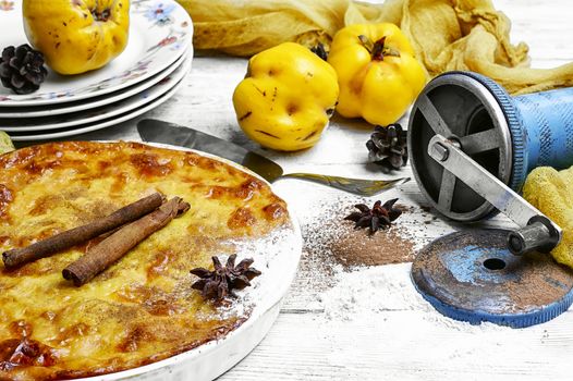 Homemade flour cake with quince and cooking utensils