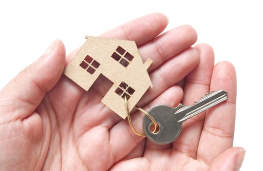 Hands holding a miniature house attached to key ring, property real estate concept 