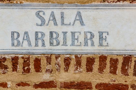 sign made of cement indicating the writing barber on a bricks wall