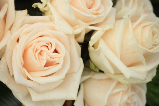 Pale pink roses in a floral arrangement at a wedding