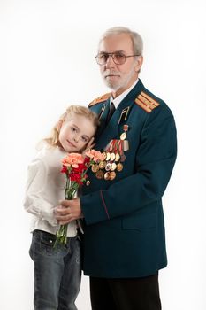 Old man in army uniform with rewards and beautiful little girl on isolated studio background