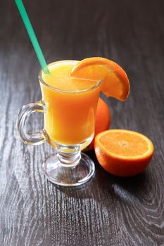 Nice goblet full of orange juice near fruits on table