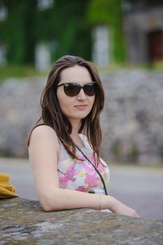 Beautiful brunette young woman wearing dress and walking on the street