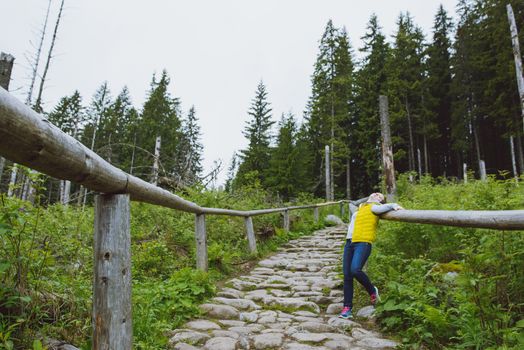 brunette woman hiker hiking on trail in summer time. Tatra mountain in Poland.