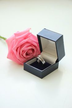 Engagement ring in box and pink rose
