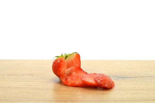 Strawberry cut into slices on a wooden background