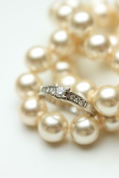 Diamond engagement ring in a channel setting and a pearl necklace
