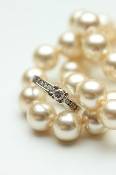 Diamond engagement ring in a channel setting and a pearl necklace