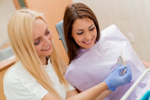 Dentist showing porcelain crowns to the female patient. 