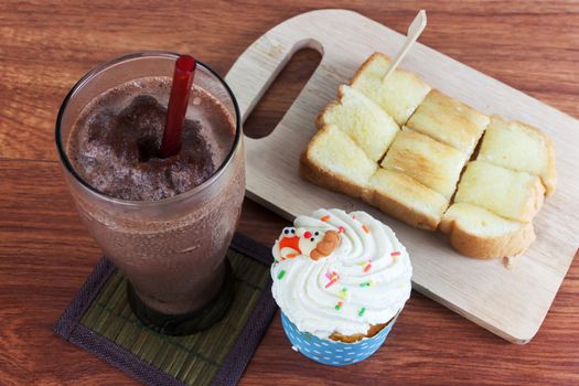 Cocoa chocolate smoothie in glass and Buttered bread and cup cake