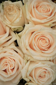 Pale pink roses in a floral arrangement at a wedding