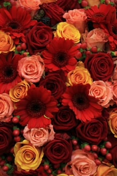 Mixed rose wedding arrangment in red, pink, orange and yellow
