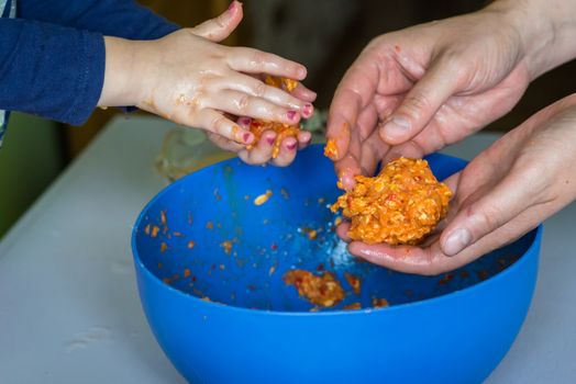 Children and dad hands prepare the raw meatballs