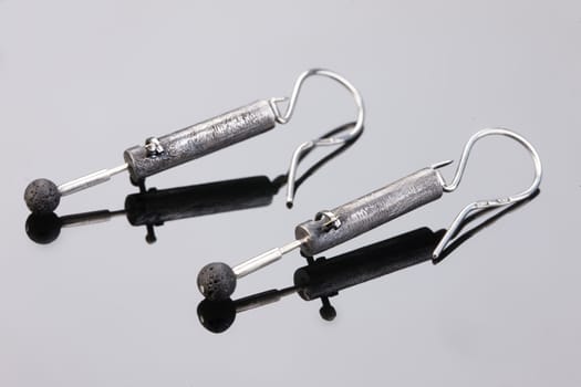 Handmade jewelry on a black glass studio background