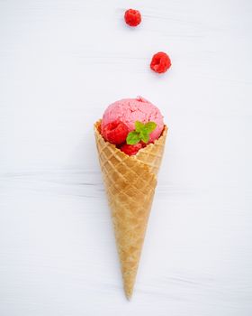 Raspberry ice cream in cone with fresh raspberry and peppermint leaves setup on white wood background  . Summer and Sweet concept flat lay.