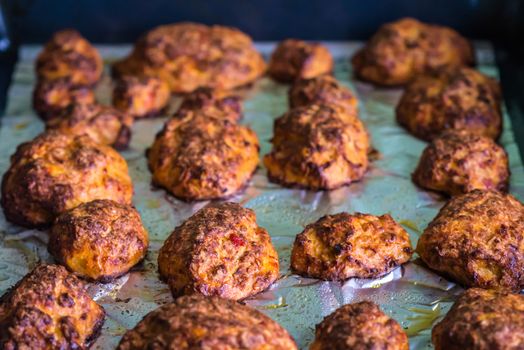 baked hot meatballs on a baking tray